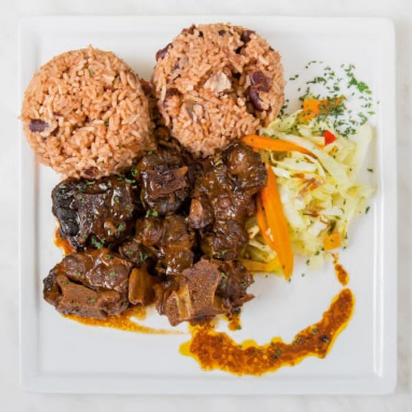 Peppas Jerk Chicken's oxtail stew with rice and peas, and a side of coleslaw.