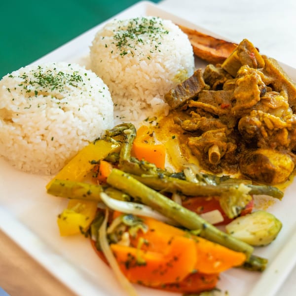 Peppas Jerk Chicken meal with two scoops of rice, stewed meat, and mixed vegetables.
